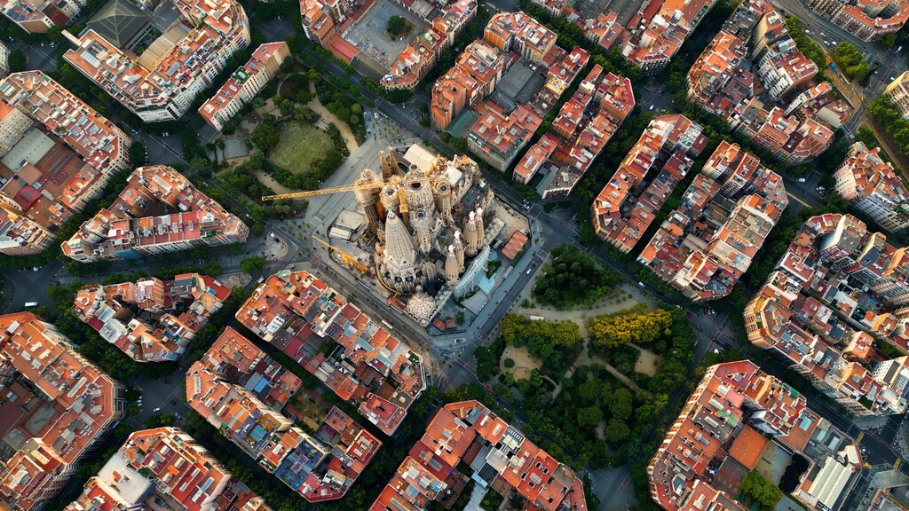 Looking down on the Sagrada Familia and surrounding buildings in Barcelona, Spain from a high up drone